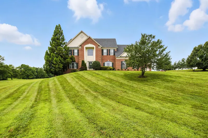 Front exterior and lawn of a brick-front colonial in Leesburg, VA